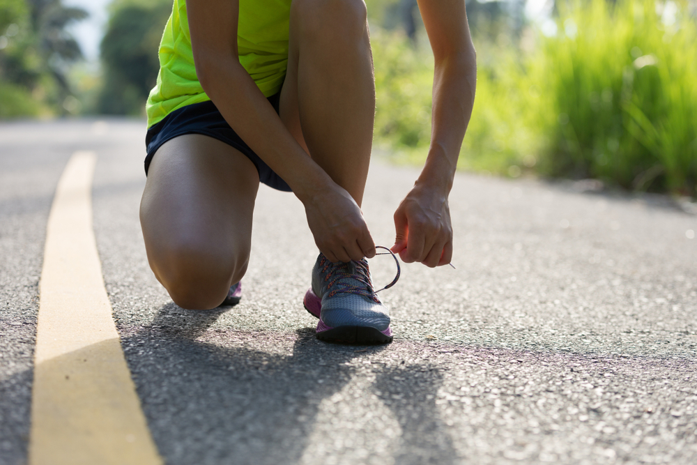 The female runner is taking steps to practice running injury prevention