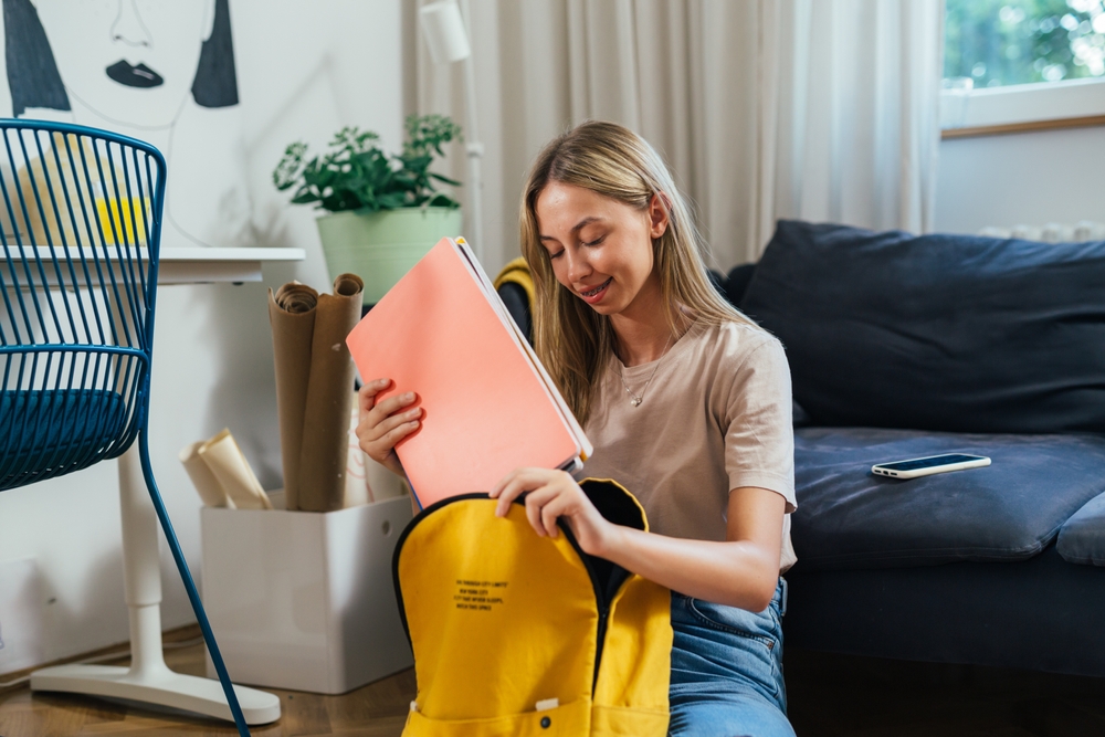 A girl packing a backpack.
